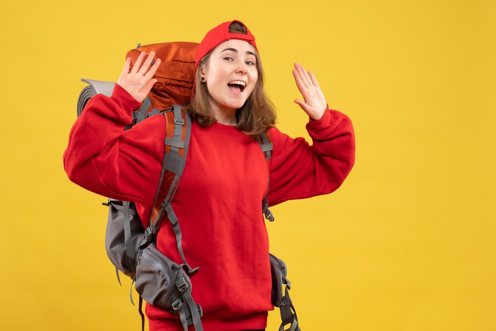 Front view happy female traveler with backpack raising hands