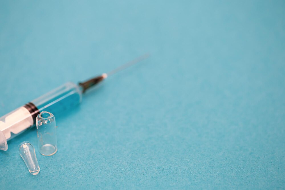 Medical syringe on a blue background closeup