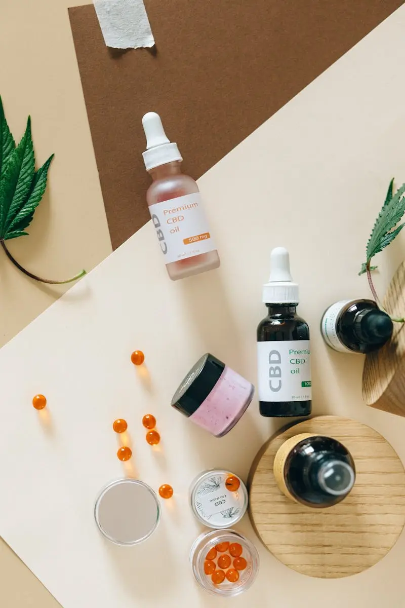 Arrangement of CBD oils, capsules, and leaves on a colorful background.